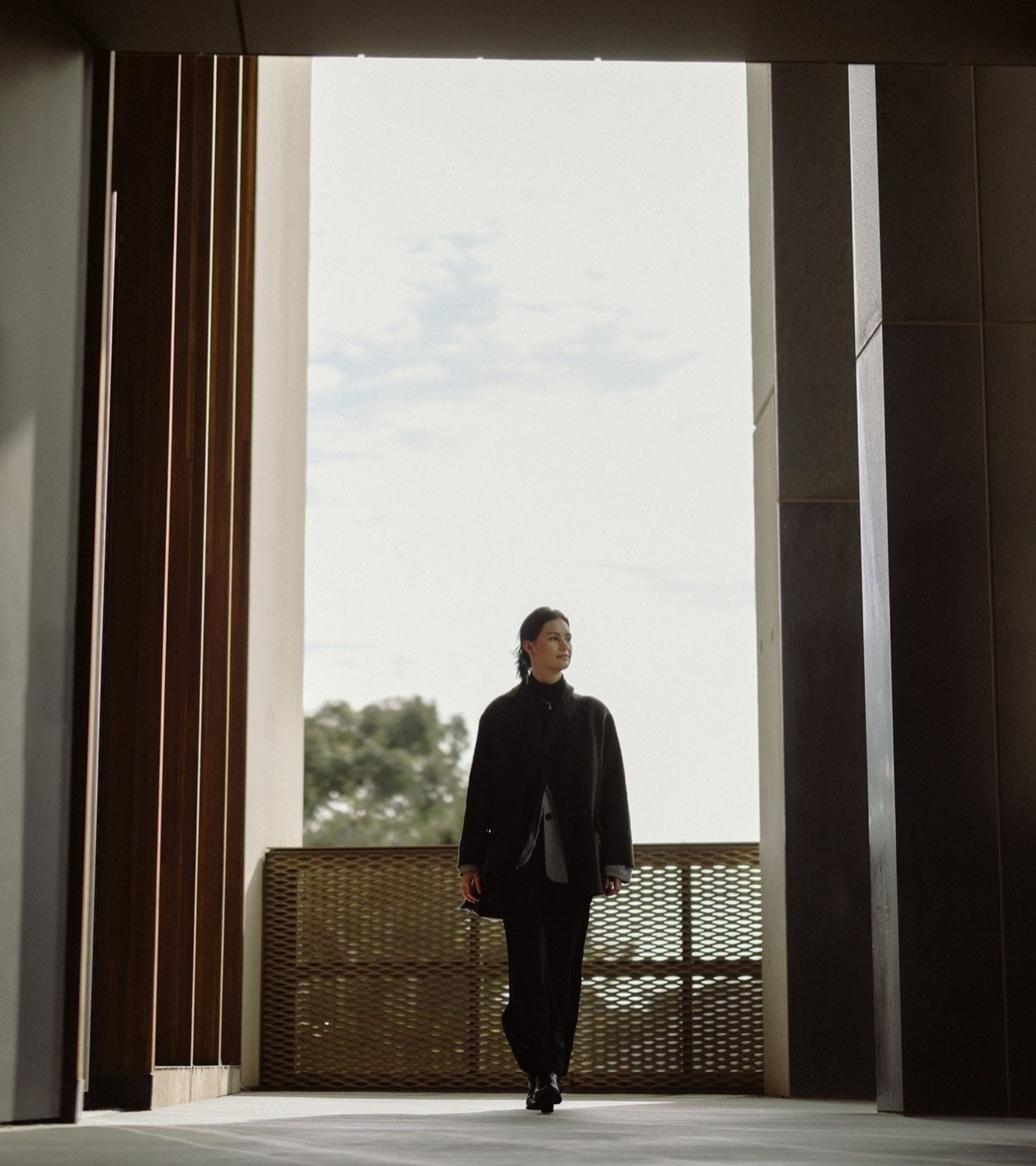 Image of young woman walking towards the camera in a dimly list passageway