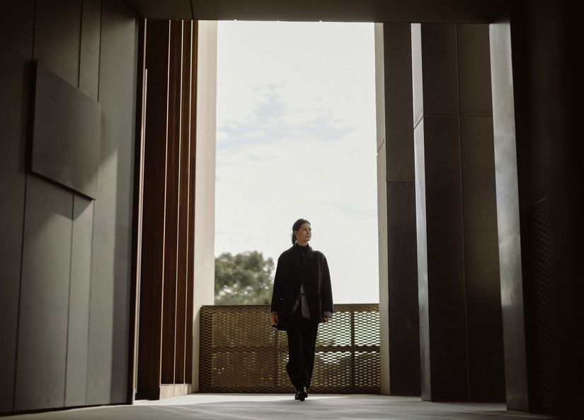 Image of young woman walking towards the camera in a dimly list passageway
