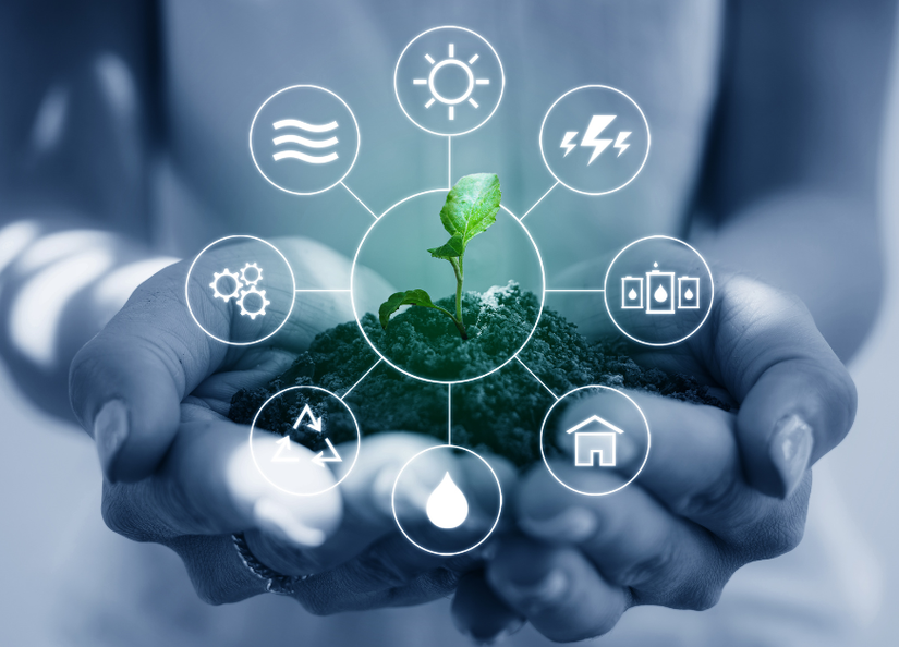 Stock image of hands holding a plant and energy symbols on a screen