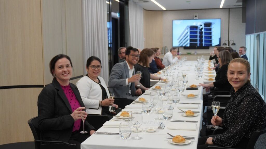 Group of staff seated at a boardroom table enjoying lunch