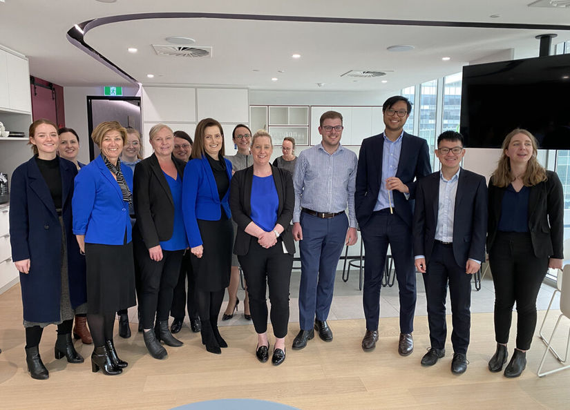Group of staff standing together wearing blue tops for Mental Health Month