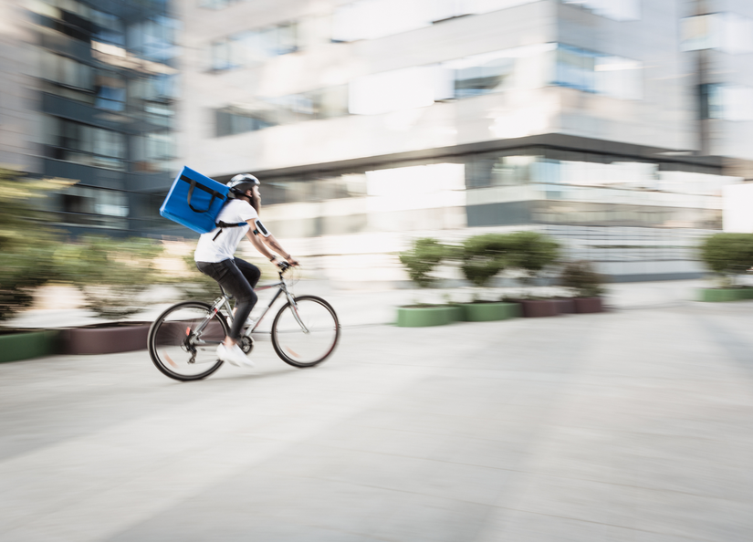 Gig economy worker riding a bike on his way to make a delivery