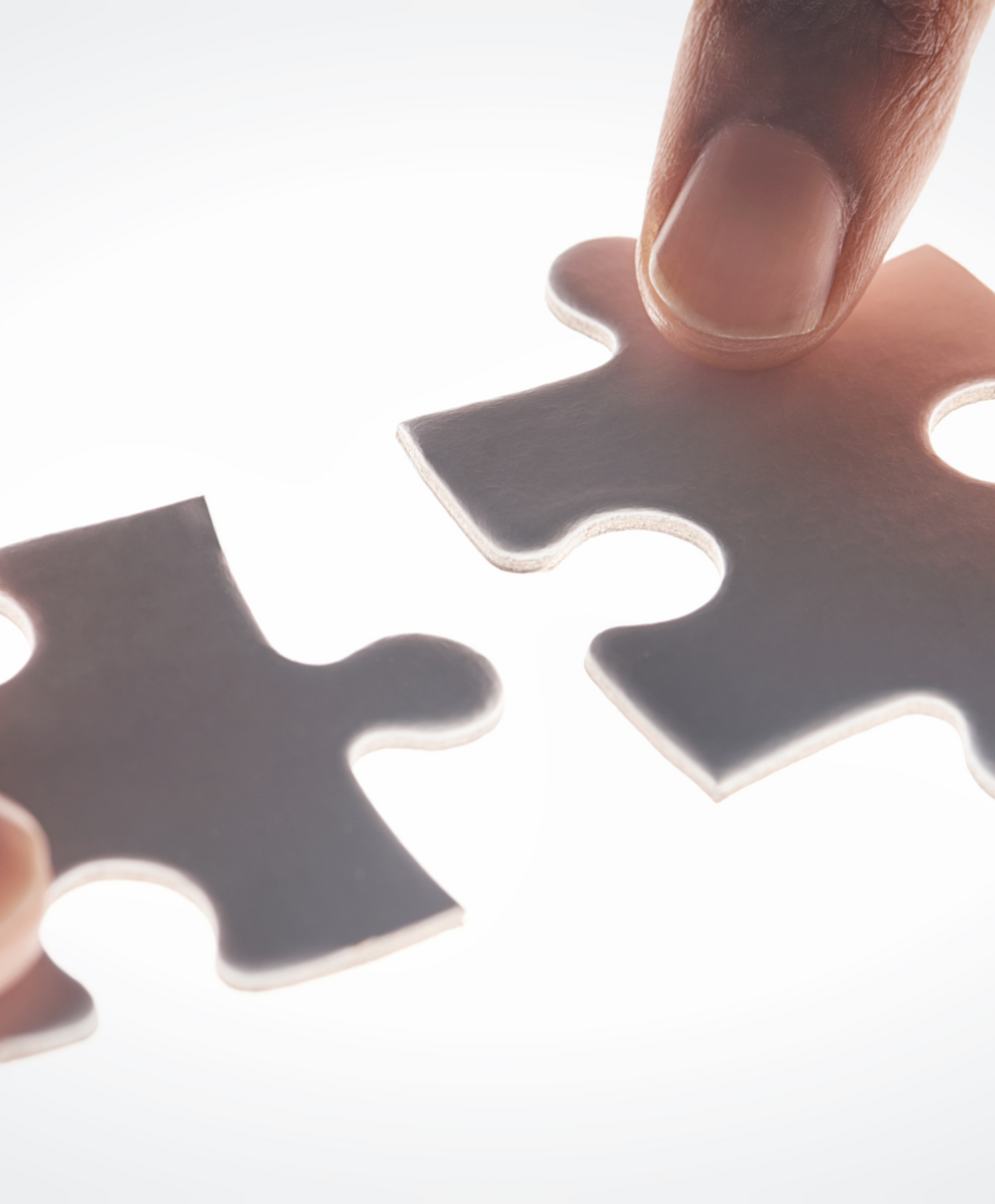 two hands putting puzzle pieces together