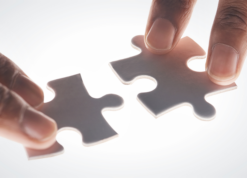 two hands putting puzzle pieces together