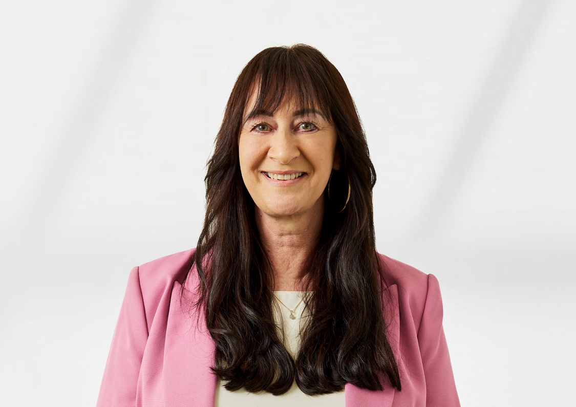 Cherie Inglis wearing a pink blazer and cream shirt. her hair is brown.