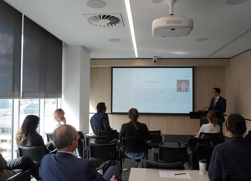 Young man presenting to a small group of professionals