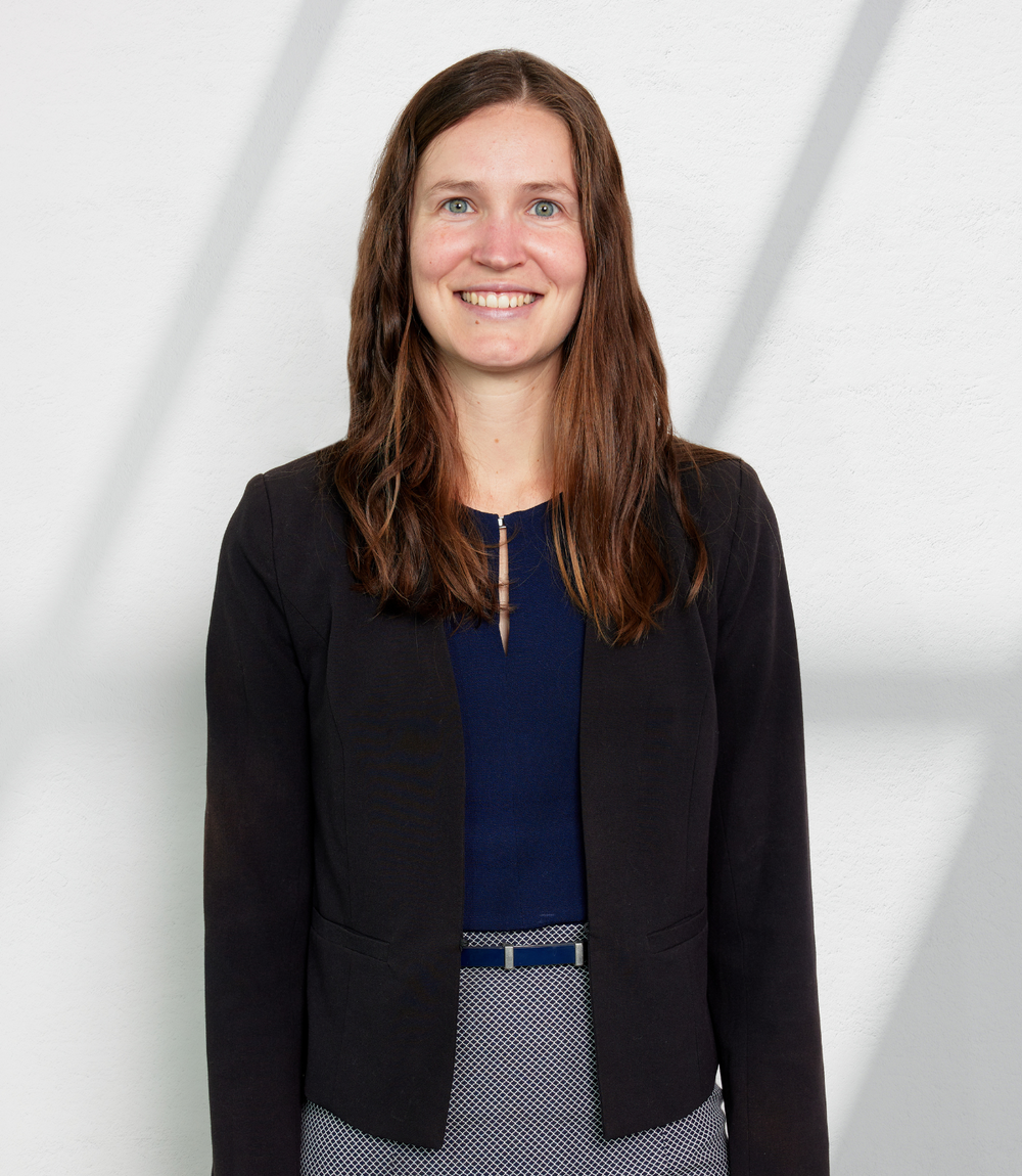 Young female Caucasian lawyer, with long brown hair posing for her headshot.