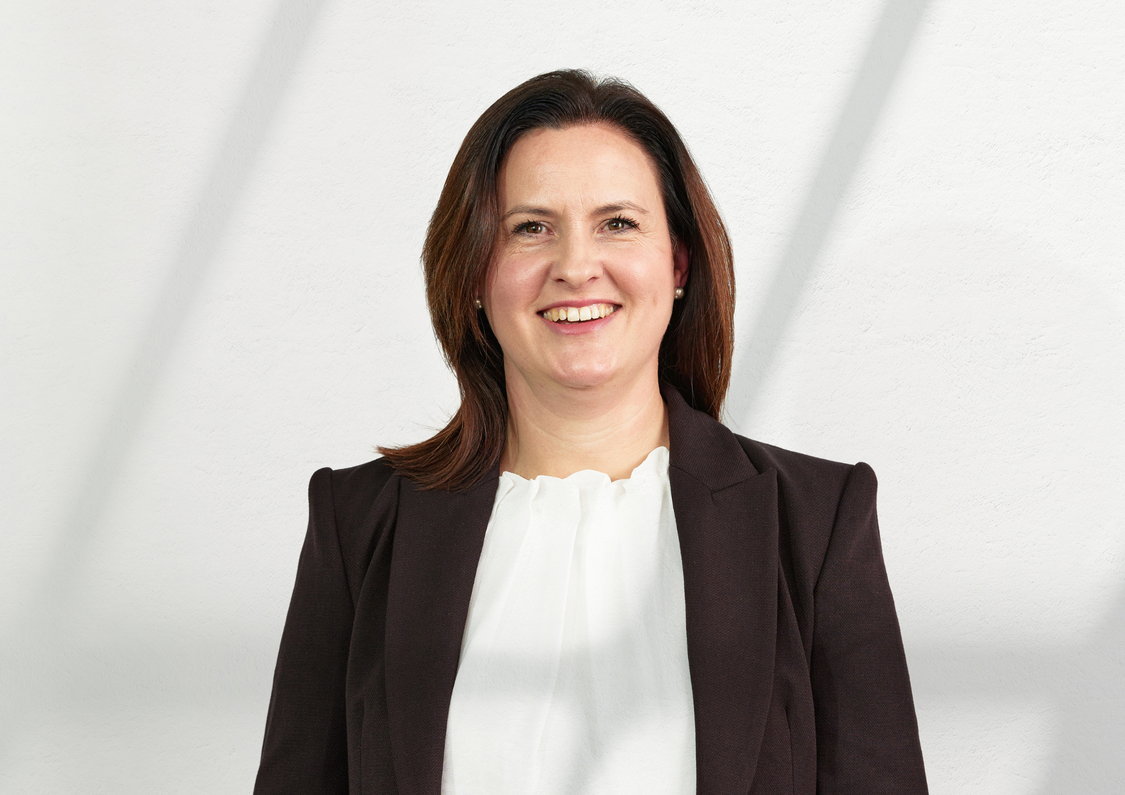 Middle aged, Caucasian, senior executive woman with brown hair posing for her headshot.
