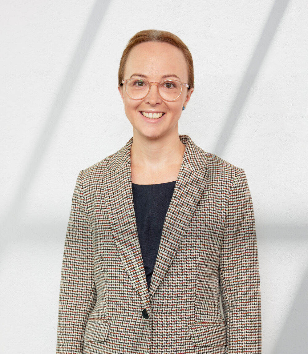 Young Caucasian woman with hair pulled back and glasses. Posing for headshot photo