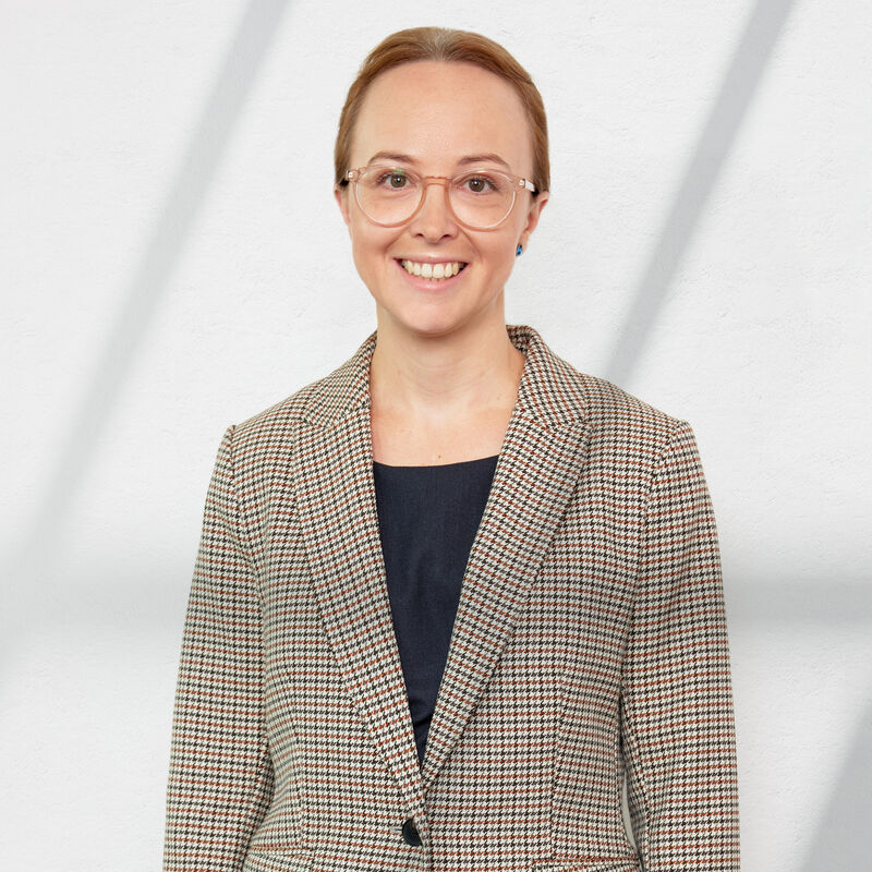 Young Caucasian woman with hair pulled back and glasses. Posing for headshot photo